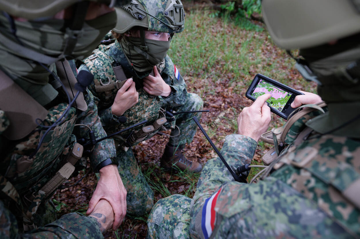 Militairen overleggen en kijken op beeldscherm raptor.